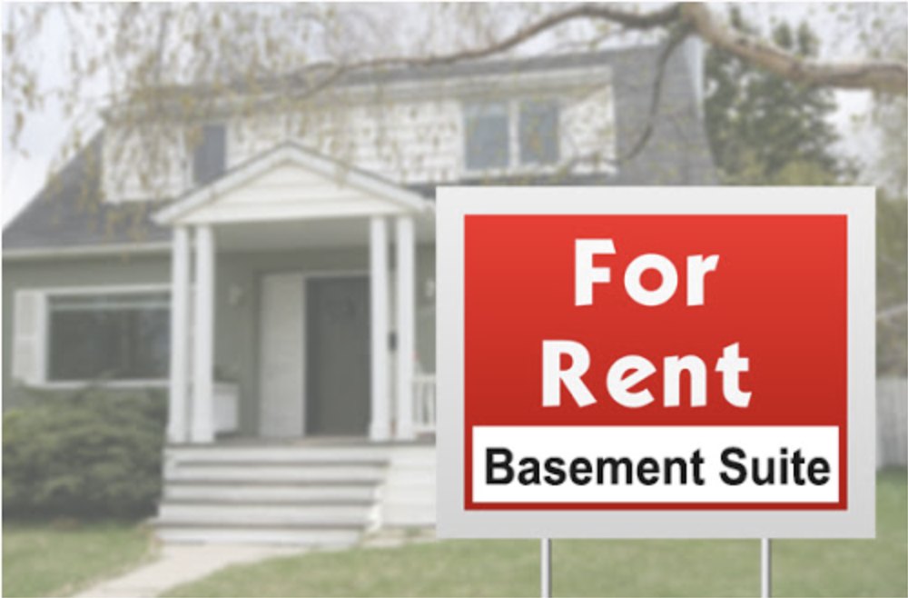 独立屋前草坪上写着 For Rent - Basement Suite 的招租牌