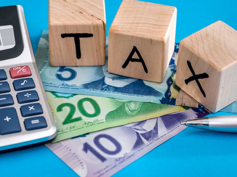 加元现钞与 TAX 字样积木